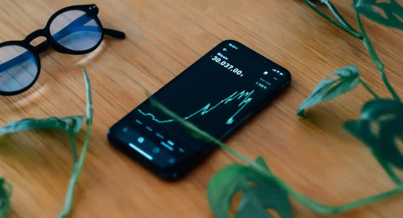 cell phone lays on a wooden table showing a chart 1536x1024 1