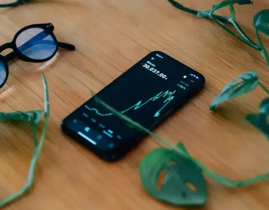 cell phone lays on a wooden table showing a chart 1536x1024 1